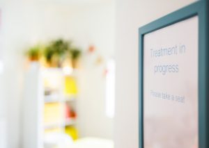'Treatment in progress' sign leading into massage treatment room