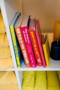 Shelves with yellow towels, candles and books