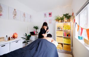 Female therapist massaging clients back with elbow in a massage room