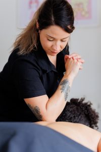 close up of female therapist massaging clients back with elbow in a massage room
