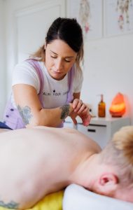 Close up of massage therapist massaging client's back with her elbow in a massage room